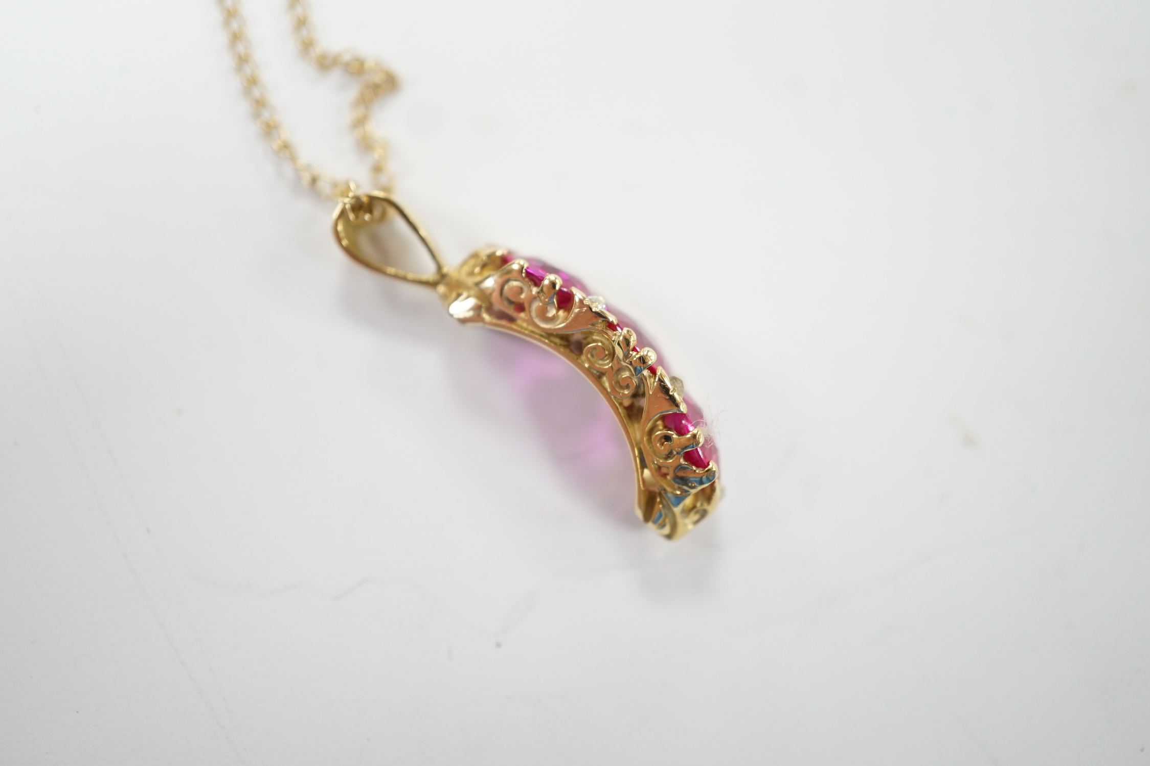 A modern 18ct gold and three stone synthetic ruby set curved pendant, with diamond chip set spacers, overall 27mm, on a 375 chain, 48cm, gross weight 4.8 grams. Fair condition.